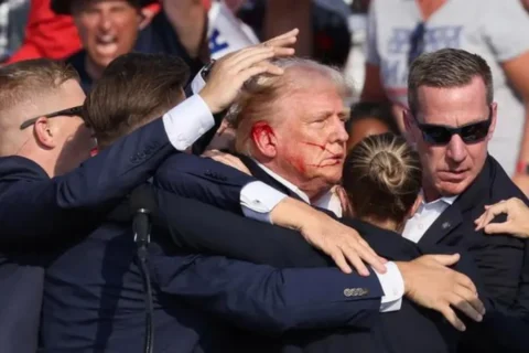 Former President Trump, with a bloodied face, gestures as multiple shots ring out during a campaign rally at the Butler Farm Show in Butler, Pennsylvania, on July 13.